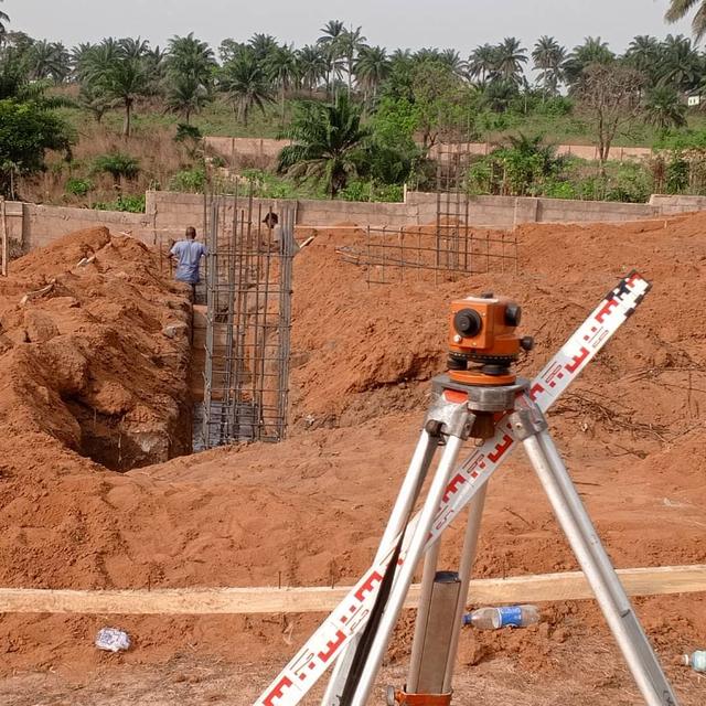 Surveying equipment on site beside column reinforcement